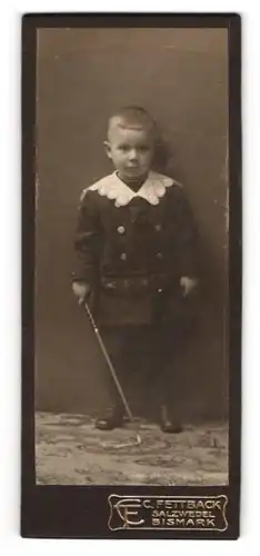 Fotografie C. Fettback, Salzwedel, Portrait kleiner Junge in hübscher Kleidung mit Stock