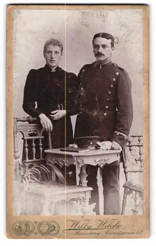 Fotografie Willy Wilcke, Hamburg, Portrait Soldat in Uniform mit Schirmmütze und Frau