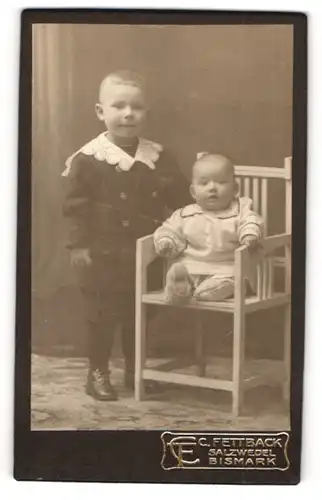 Fotografie C. Fettback, Salzwedel, Portrait kleiner Junge in hübscher Kleidung und Baby