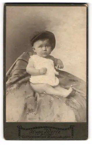 Fotografie Hugo Werle, Goslar, Portrait sitzendes Kleinkind im weissen Hemd mit Hut