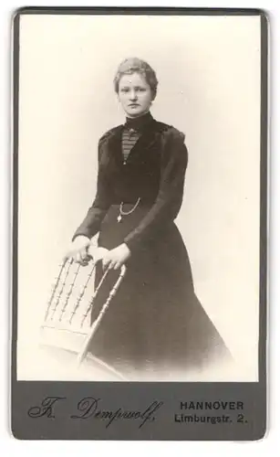 Fotografie Fr. Dempwolf, Hannover, Portrait junge Dame im schwarzen Kleid an Stuhl gelehnt