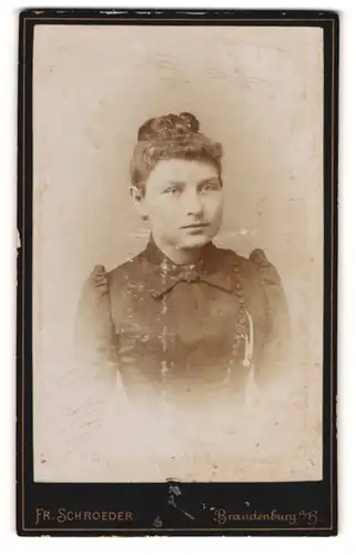 Fotografie Fr. Schroeder, Brandenburg a / H., Portrait junge Dame im schwarzen Kleid mit Kragenbrosche