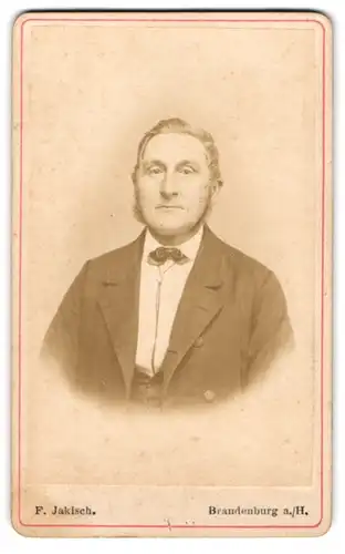 Fotografie F. Jakisch, Brandenburg a. H., Mann mit Koteletten und Fliege