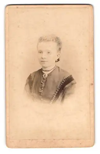 Fotografie H. Eykum, Brandenburg a. H., Frau mit Kreuzhalskette in dekorativer Tracht
