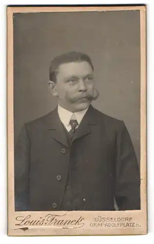 Fotografie Louis Franck, Düsseldorf, Mann mit kurzen Haaren und Schnauzbart im Anzug