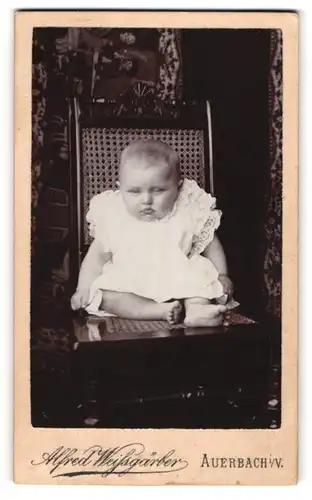 Fotografie Alfred Weissgärber, Auerbach i. V., Süsses Kleinkind im Kleid mit nackigen Füssen