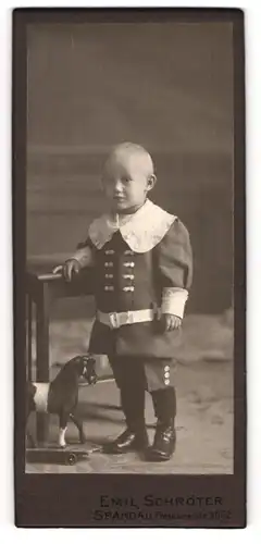 Fotografie Emil Schröter, Spandau, Potsdamerstr. 31 /32, Niedliches Kleinkind mit Spitzenkragen und Schaukelpferd