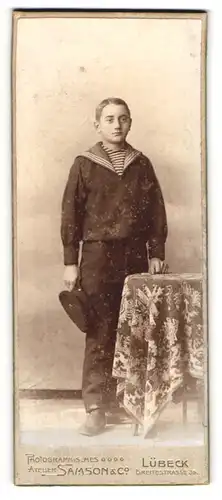 Fotografie Samson & Co., Lübeck, Breitestr. 39, Hübscher Junge im Matrosenanzug und mit Uniformmütze in der Hand
