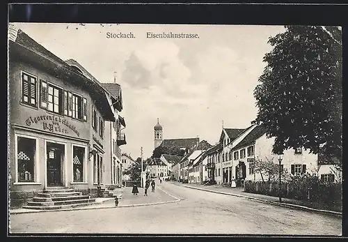 AK Stockach, Eisenbahnstrasse mit Geschäften und Blick zur Kirche