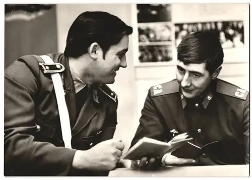 Fotografie Fotograf unbekannt, DDR Volkspolizist und Rjadowoi / Rotarmist in Uniform vergleichen ihre Dienstbücher