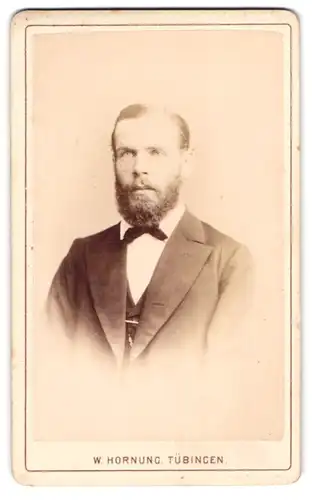 Fotografie W. Hornung, Tübingen, Portrait stattlicher Herr im Anzug mit Fliege und Vollbart