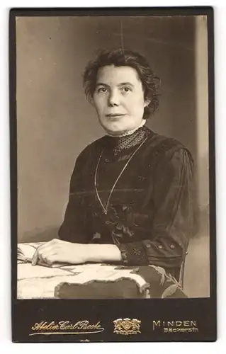 Fotografie Carl Beste, Minden, Portrait bürgerliche Dame mit Buch am Tisch sitzend