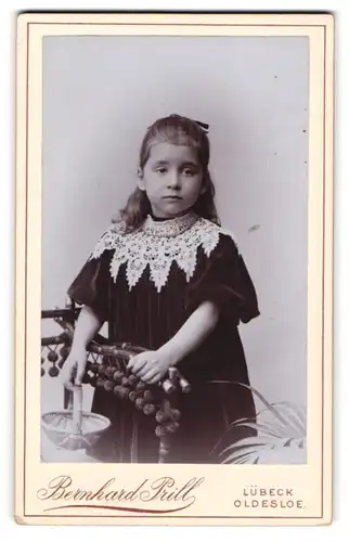 Fotografie Bernhard Prill, Lübeck, Kleines Mädchen in schwarzem Kleid mit weissem Zierkragen