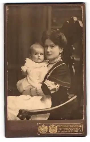 Fotografie Pieperhoff & Fendius, Magdeburg, Dame mit hochgesteckten Haaren hält ihr Baby in weissem Kleidchen