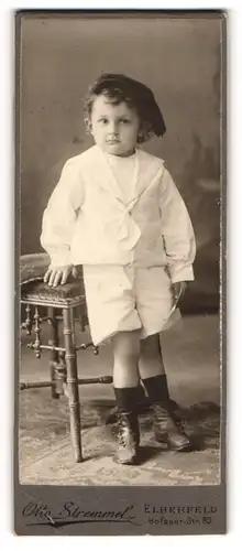 Fotografie Otto Stremmel, Elberfeld, Portrait kleiner Junge im Matrosenanzug an Hocker gelehnt