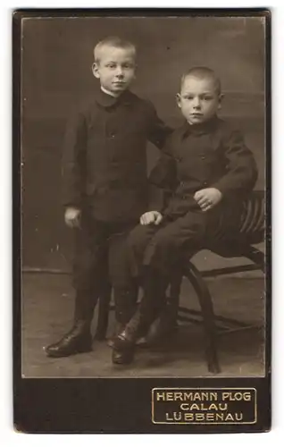 Fotografie Hermann Plog, Calau, Portrait zweier kleiner Jungen in modischer Kleidung am Stuhl