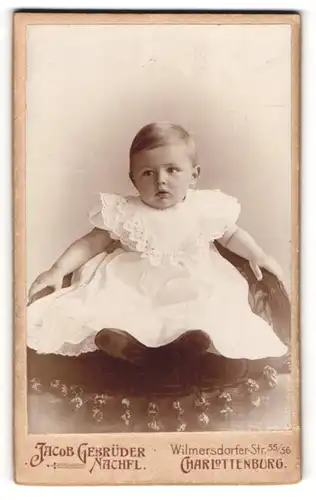 Fotografie Jacob Gebrüder Nachfl., Charlottenburg, Portrait Kleinkind in weissem Kleid