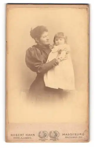 Fotografie Robert Hahn, Magdeburg, Dame in schwarzem Kleid hält ihre kleine Tochter