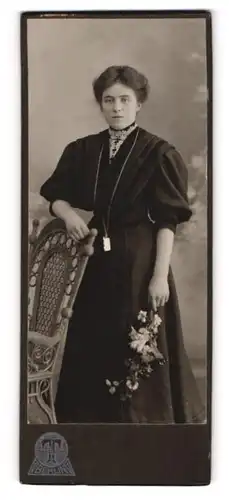 Fotografie Hermann Tietz, Berlin, Portrait bürgerliche Dame mit Blumen an Stuhl gelehnt