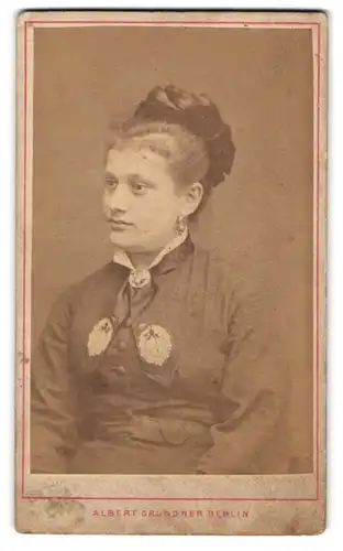 Fotografie Albert Grundner, Berlin, Portrait junge Dame mit Hochsteckfrisur und Kragenbrosche