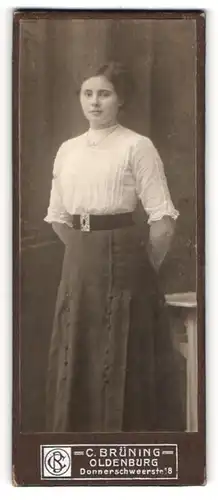 Fotografie C. Brüning, Oldenburg, Junge Frau mit zurückgesteckten Haaren trägt weisse Bluse und dunklen Rock