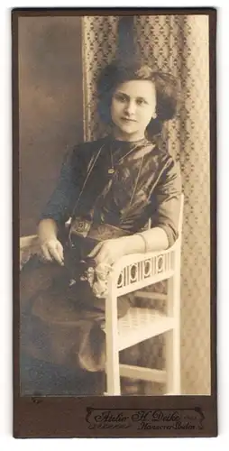 Fotografie Atelier H. Deike, Hannover, Junge Frau mit toupiertem Haar sitzt in weissem Stuhl