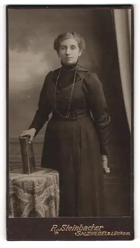 Fotografie R. Steinbacher, Salzwedel, Portrait junge Frau in schwarzem Kleid