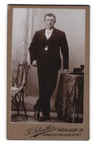 Fotografie R. Schrötter, Mühldorf am Inn, Portrait junger Herr in eleganter Kleidung an Tisch gelehnt