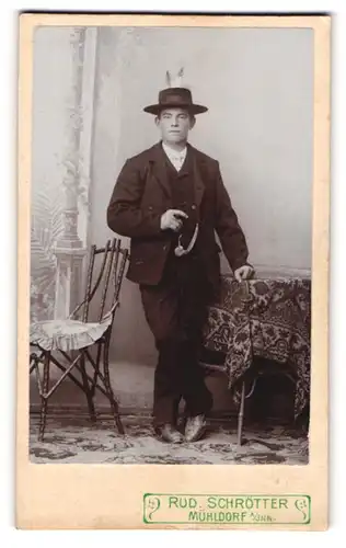 Fotografie Rud. Schötter, Mühldorf a / Inn, Portrait modisch gekleideter Herr mit Zigarre an Tisch gelehnt