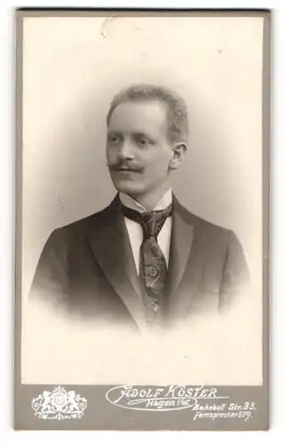 Fotografie Adolf Köster, Hagen i / W., Portrait junger Mann im Anzug mit Krawatte und Zwirbelbart