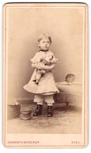 Fotografie Schmidt & Wegener, Kiel, niedliches kleines Mädchen mit Puppe im Arm