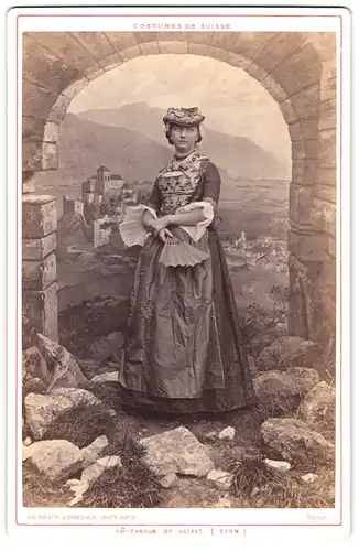 Fotografie Ad. Braun, Dornach, junge Dame im Trachtenkleid aus Wallis vor einer schönen Studiokulisse