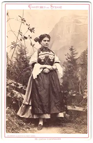 Fotografie Ad. Braun, Dornach, Schweizer Dame in Tracht aus Unterwalden vor einer Studiokulisse