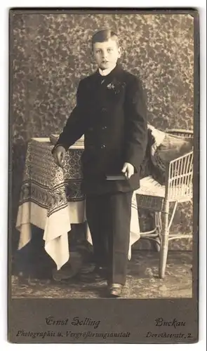 Fotografie Ernst Golling, Buckau, Dorotheenstr. 2, Halbwüchsiger Knabe im Anzug mit einem Buch