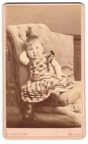 Fotografie E. Faehling, Berlin, Leipziger Str. 63a, Süsses kleines Mädchen im karierten Kleid auf einem Sessel
