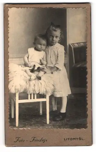 Fotografie Findejs, Litomysl, Niedliche kleine Geschwister in weisser Kleidung halten sich im Arm