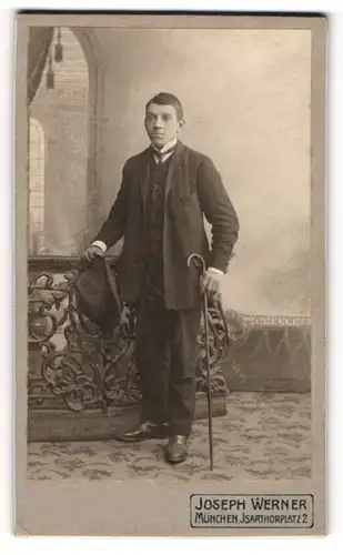 Fotografie Joseph Werner, München, Isarthorplatz 2, Bürgerlicher junger Mann mit Hut und Gehstock in Anzug und Krawatte