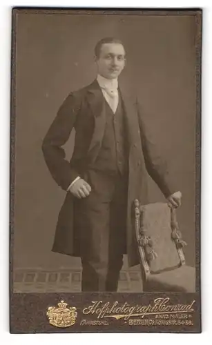 Fotografie Rudolph Conrad, Berlin, Königstrasse 36, Eleganter Herr im Dreiteiler mit Gehrock und weisser Krawatte