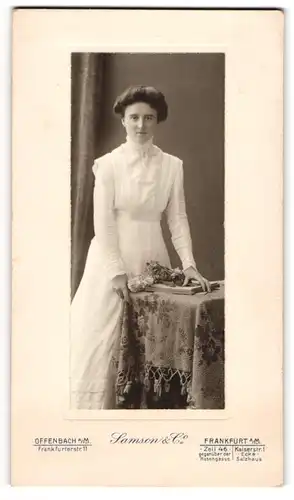 Fotografie Samson & Co., Offenbach a. M., Frankfurterstr. 11, Junge Dame in weissem Kleid mit Blumenstrauss und Lächeln