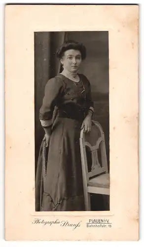 Fotografie Strauss, Plauen i. V., Bahnhofstr. 19, Dame in dunklem tailliertem Kleid mit langer Kette und Brosche