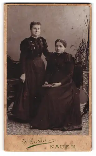 Fotografie J. Laski, Nauen, Dammstr. 17, Schwesternpaar in schwarzen Kleidern mit Buch und leichtem Lächeln