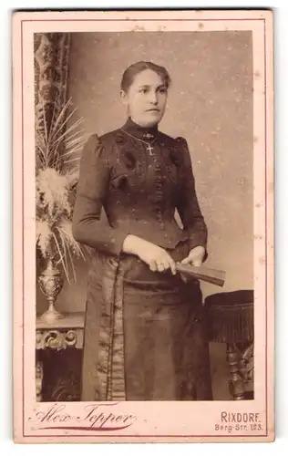 Fotografie Alex Tepper, Rixdorf, Berg-Str. 123, Dame in dunklem Kleid mit silberner Kreuzkette und Fächer