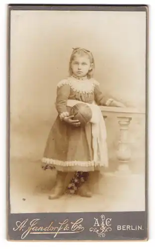 Fotografie A. Jandorf & Co., Berlin, Spittelmarkt 16, Junges Mädchen im Kleid mit Ball und Haarband