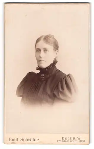 Fotografie Emil Schröter, Berlin, Potsdamerstr. 116, Junge Dame in schwarzem Kleid mit hohem Kragen und Brosche