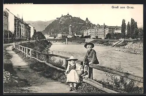 AK Graz, Blick zum Schlossberg, Kinder in Tracht stehen am Ufer