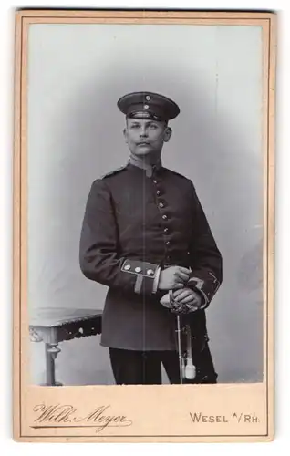 Fotografie Wilh. Myer, Wesel a / Rh., Portrait Soldat in Uniform mit Schirmmütze und Degen