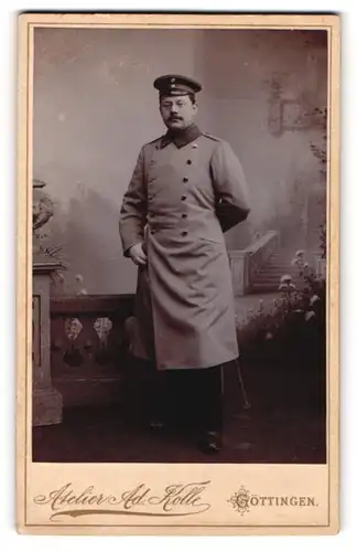Fotografie Adolf Kolle, Göttingen, Portrait Soldat im Uniformmantel mit Schirmmütze