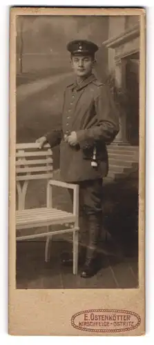 Fotografie E. Ostenkötter, Hirschfelde-Ostritz, Junger Soldat in Uniform posiert neben weisser Bank