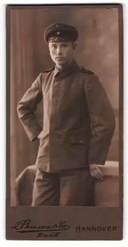 Fotografie Samson & Co., Hannover, Junger Soldat trägt Uniform mit schwarzen Schulterklappen und Schirmmütze