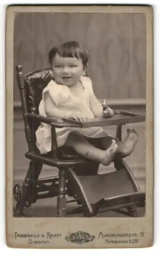 Fotografie Taggeselle & Ranft, Dresden, Portrait lachendes süsses Mädchen mit Spielzeug im Kinderstuhl sitzend